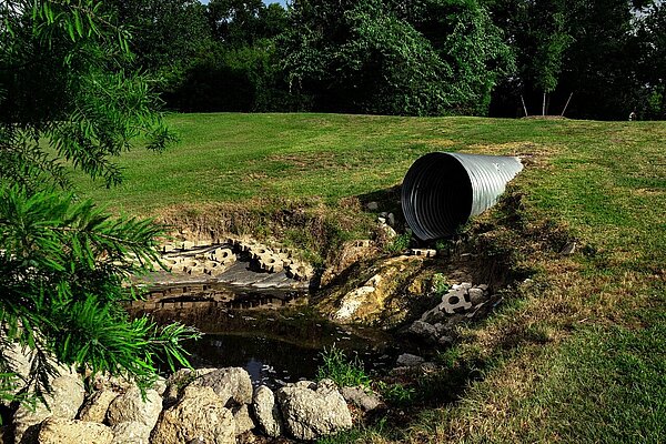 Sewage pipe next to a waterway